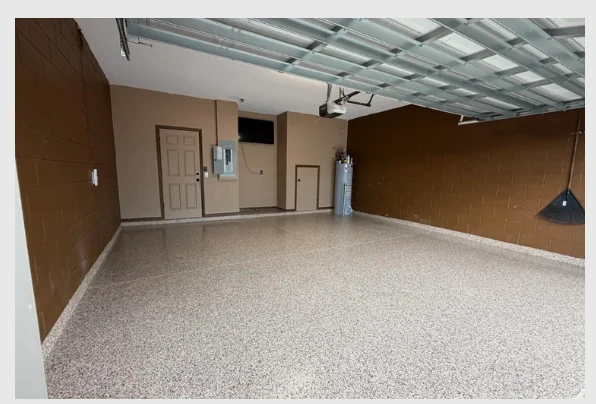 Finished residential garage with a seamless gray decorative flake epoxy floor and freshly coated edges