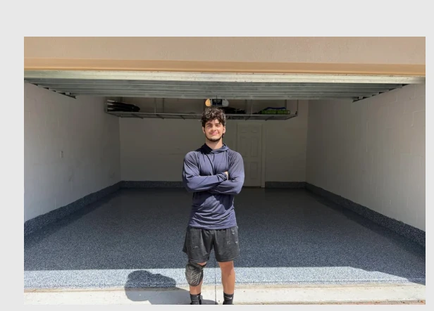 Fine Flakes Epoxy contractor standing in a garage with a freshly finished decorative gray flake floor